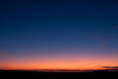 Scenic view of silhouette field against romantic sky at sunset