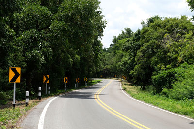 Road amidst trees against sky