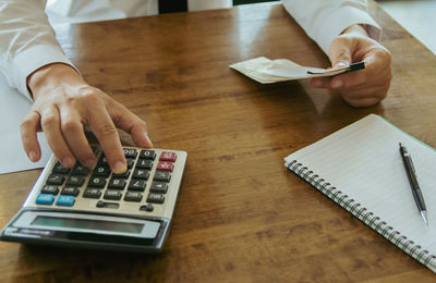 Midsection of businessman working at table