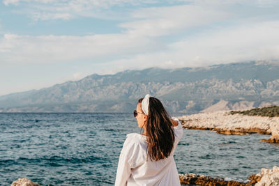 Woman looking at sea against mountain