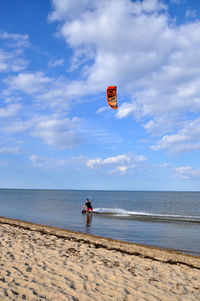 Man flying over sea against sky