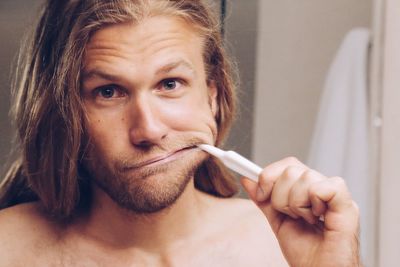 Close-up portrait of man brushing teeth