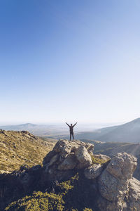 People standing on rock against sky