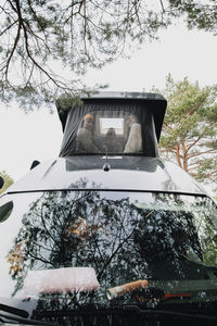 Friends spending leisure time in roof tent of camper van