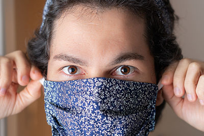 Close-up portrait of mid adult woman covering face