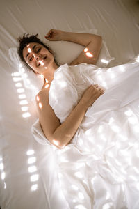 High angle view of woman lying on bed