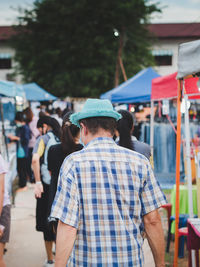 Rear view of people standing on street market