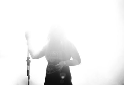 Rear view of woman standing against clear sky