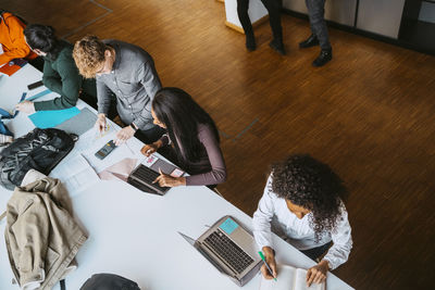 High angle view of multiracial students studying at table in community college