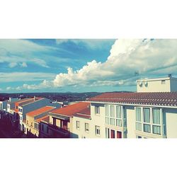 Buildings against cloudy sky