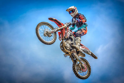 Low angle view of man riding bicycle against sky