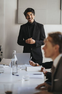 Happy businessman with hands clasped during business meeting at office