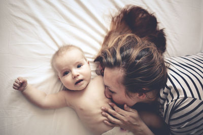 Mother gently hugs son, top view, white background. concept motherhood and emotions.