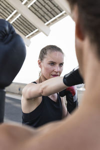 Female athlete with male instructor practicing boxing