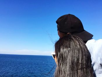 Rear view of woman looking at sea against clear sky