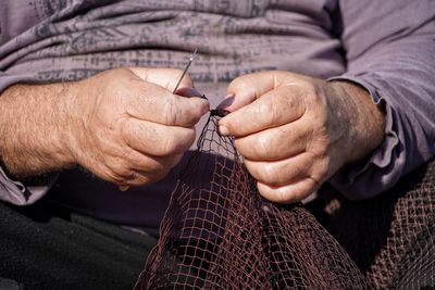 Midsection of man holding fishing net