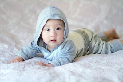 Portrait of cute baby girl sleeping on bed at home