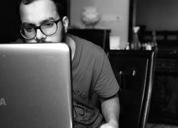 Close-up of man using mobile phone at home