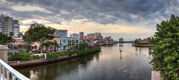 River amidst buildings in city against sky