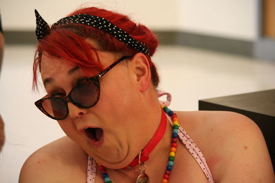 Close-up of redhead lesbian woman making a face while wearing sunglasses