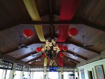 Low angle view of illuminated chandelier hanging from ceiling