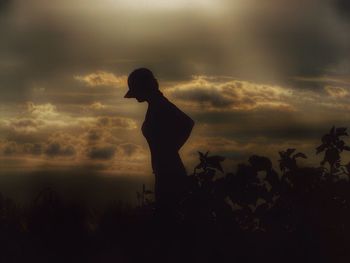 Silhouette woman standing against sky during sunset