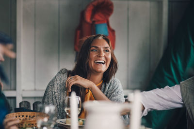 Portrait of smiling young woman sitting on table