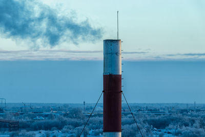 Lighthouse by sea against sky