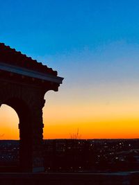 Silhouette of building against sky during sunset