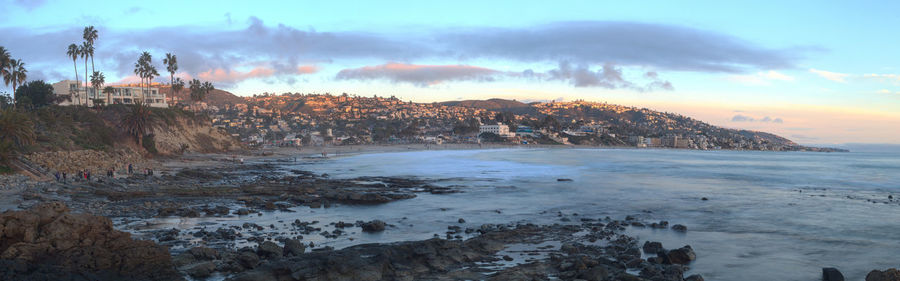 Scenic view of mountain by beach against sky during sunset