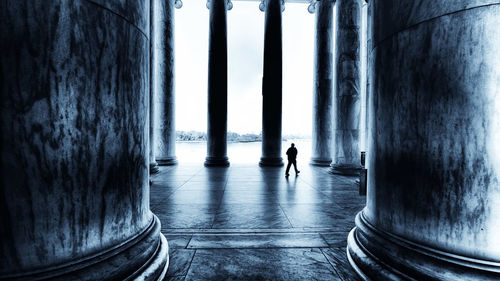 Silhouette man walking on tiled floor