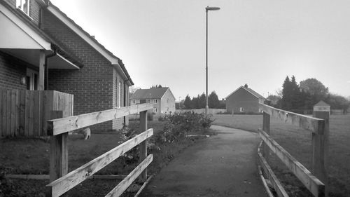 Road by buildings against clear sky