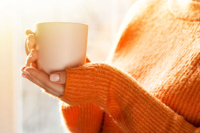 Midsection of woman holding coffee cup