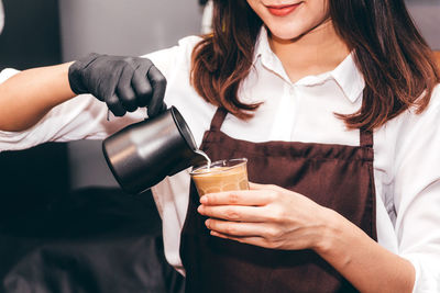 Midsection of woman drinking glass