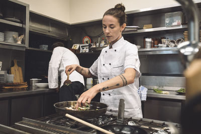 Female chef preparing food at restaurant