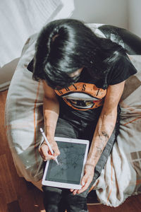 High angle view of woman using mobile phone at home