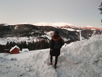 Full length rear view of man walking on snow