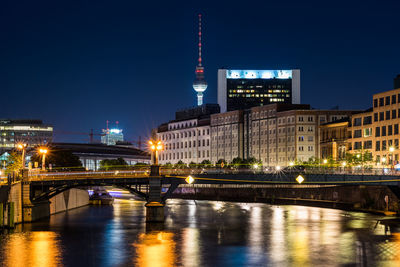 View of illuminated bridge over river at night