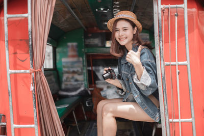 Young woman using mobile phone while sitting in traditional clothing