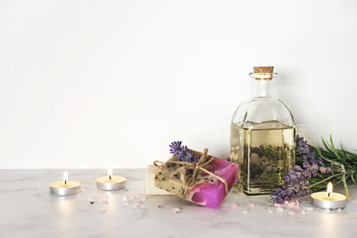 Spa setting, lavender cosmetics products and burning candles. home body skin care, spa  background.