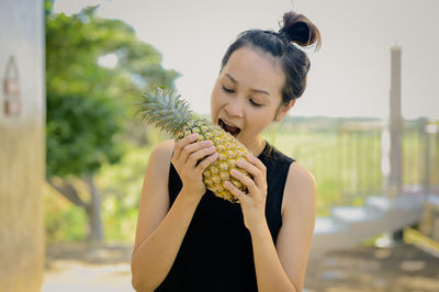 Young woman holding pineapple