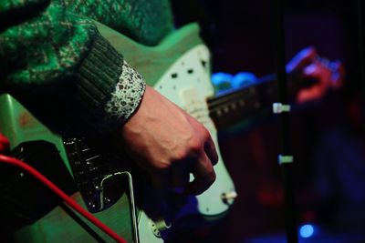 Midsection of man playing guitar