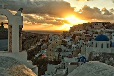 Buildings in town against sky during sunset