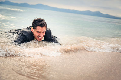 Portrait of smiling boy on beach against sky