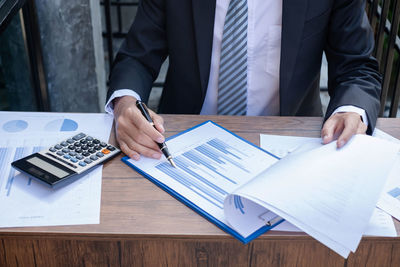 Midsection of business colleagues working on table