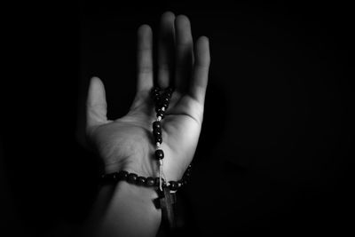Close-up of woman hand over black background