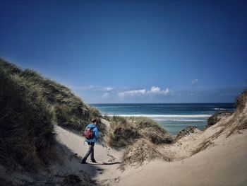 Rear view of people walking on beach