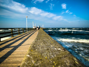 Surface level of pier over sea against sky