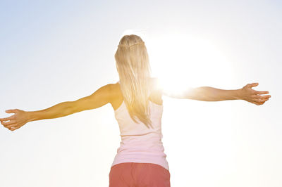 Smiling young woman with outstretched arms