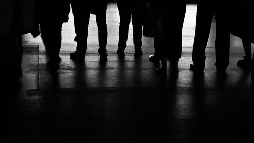 Low section of people standing on wooden floor